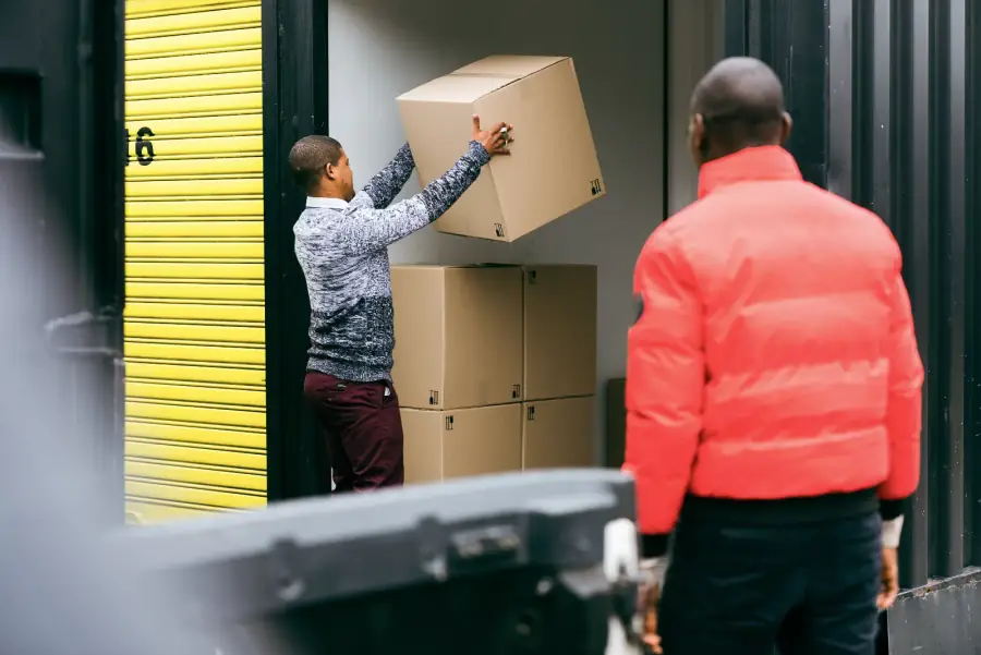 Customers loading boxes from a trailer into a storage unit at Cape Storit Paarden Eiland