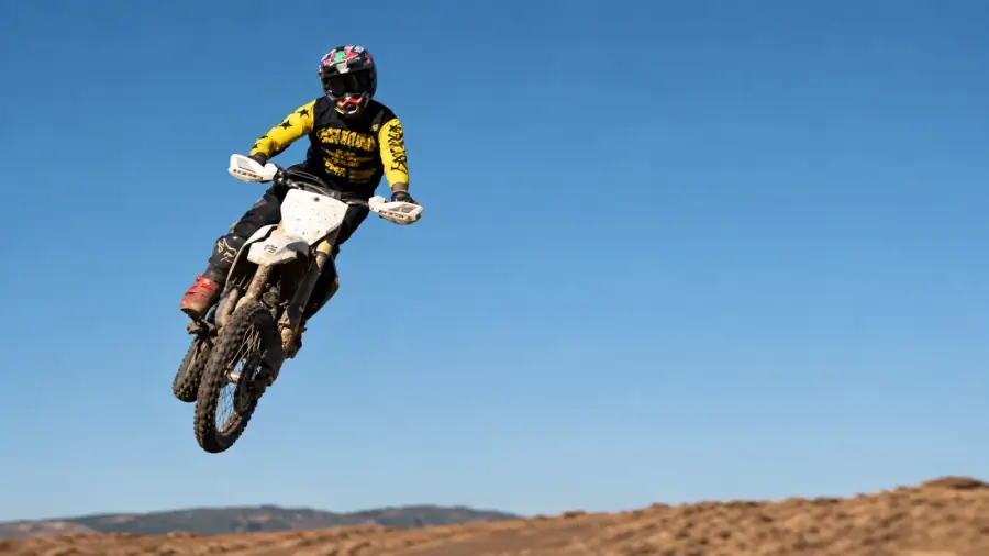 Motocross rider mid-jump — Cape Storit stores bikes trackside at Zone 7