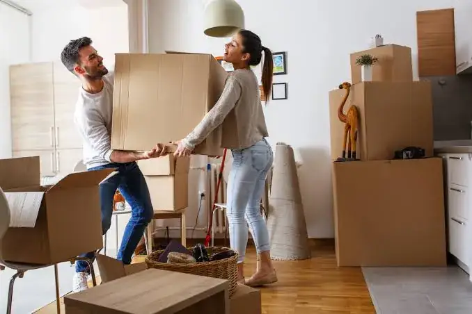 Couple carrying boxes while moving home in Cape Town
